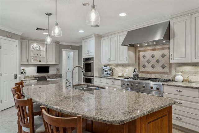 3906 Floyd Rd, Tampa, FL 33618 - kitchen featuring wall chimney exhaust hood, crown molding, an island with sink, appliances with stainless steel finishes, and tasteful backsplash