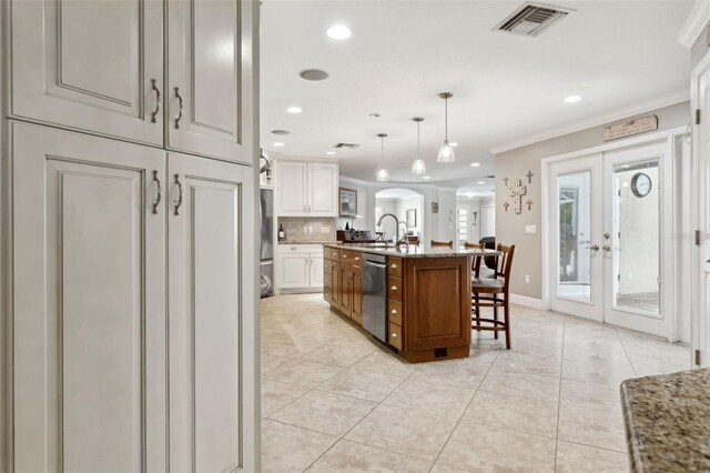 3906 Floyd Rd, Tampa, FL 33618 - kitchen featuring crown molding, a sink, appliances with stainless steel finishes, french doors, and a breakfast bar area