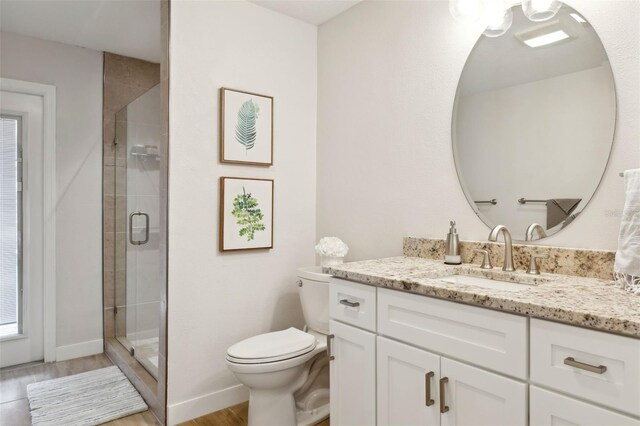 3906 Floyd Rd, Tampa, FL 33618 - bathroom with vanity, toilet, a stall shower, wood finished floors, and baseboards