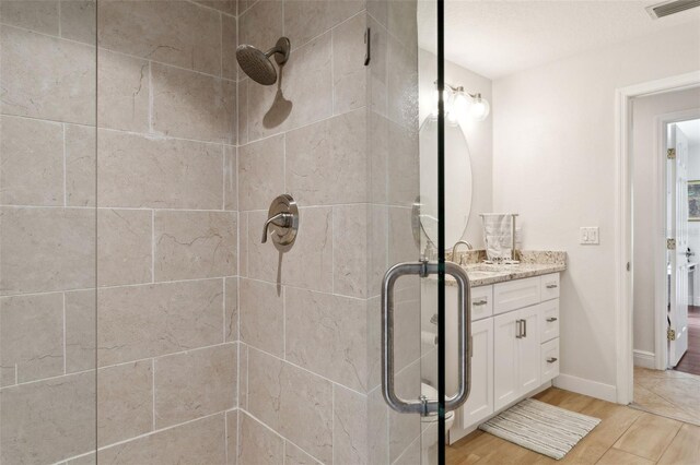 3906 Floyd Rd, Tampa, FL 33618 - bathroom with a stall shower, vanity, wood finished floors, and baseboards