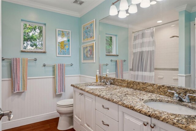 3906 Floyd Rd, Tampa, FL 33618 - bathroom featuring toilet, healthy amount of natural light, wood finished floors, ornamental molding, and wainscoting
