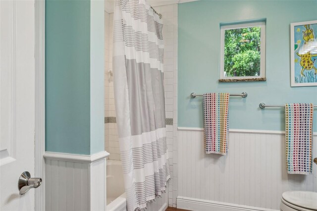 3906 Floyd Rd, Tampa, FL 33618 - bathroom with a wainscoted wall, toilet, and shower / bath combo