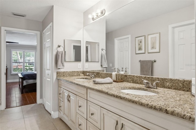 3906 Floyd Rd, Tampa, FL 33618 - ensuite bathroom featuring double vanity, tile patterned flooring, and baseboards