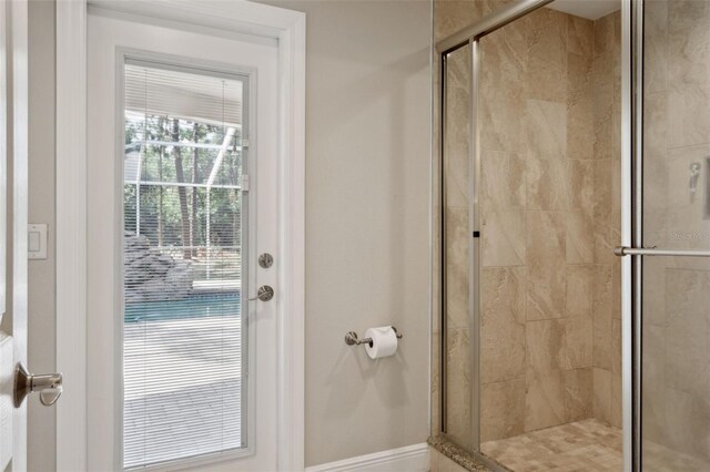 3906 Floyd Rd, Tampa, FL 33618 - bathroom featuring a stall shower and baseboards