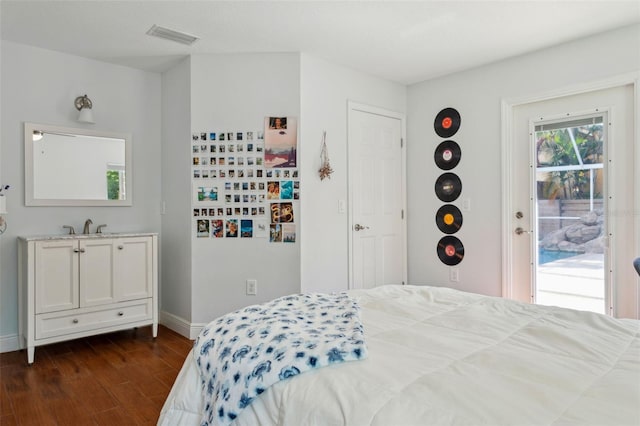 3906 Floyd Rd, Tampa, FL 33618 - bedroom featuring access to exterior, dark wood-style floors, and baseboards