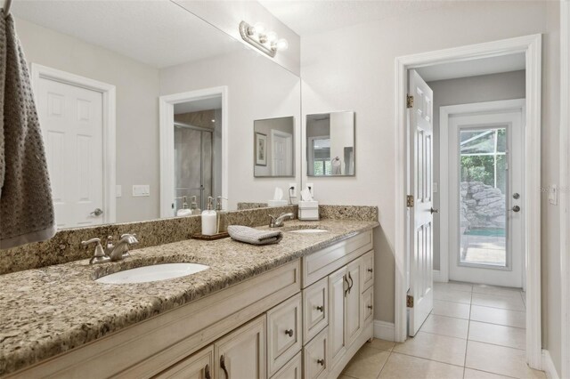 3906 Floyd Rd, Tampa, FL 33618 - full bath featuring double vanity, tile patterned flooring, a shower stall, and baseboards