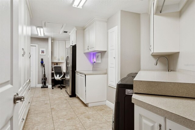 3906 Floyd Rd, Tampa, FL 33618 - kitchen featuring freestanding refrigerator, white cabinetry, light countertops, light tile patterned flooring, and baseboards
