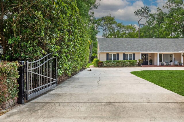 3906 Floyd Rd, Tampa, FL 33618 - view of front of house featuring stucco siding, a gate, driveway, and a front lawn