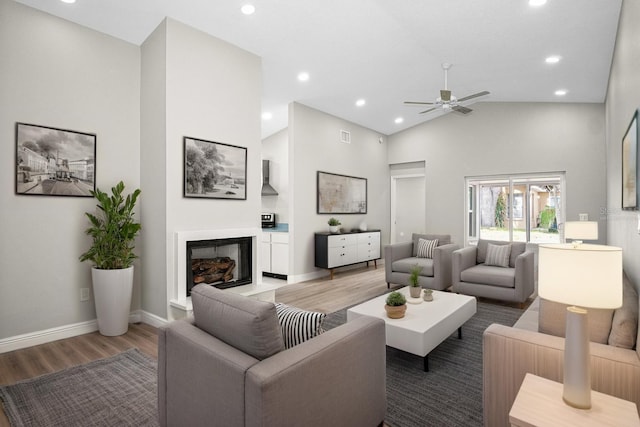 13613 Laraway Dr, Riverview, FL 33579 - living area featuring light wood finished floors, a glass covered fireplace, high vaulted ceiling, ceiling fan, and recessed lighting
