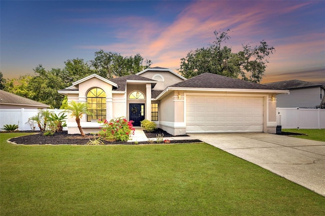 ranch-style house featuring an attached garage, fence, driveway, and stucco siding