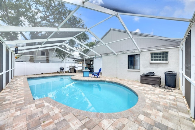 view of swimming pool featuring a fenced in pool, fence, glass enclosure, and a patio area