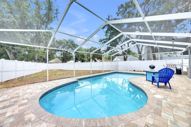 view of swimming pool with a patio, a fenced backyard, glass enclosure, and a fenced in pool
