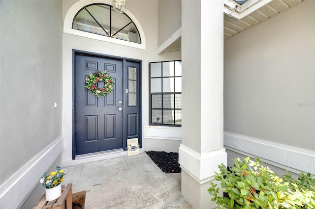 property entrance with stucco siding and a porch