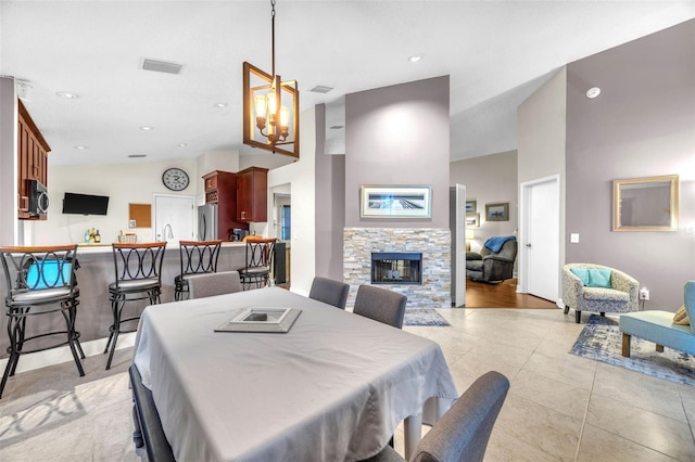 dining area with visible vents, a fireplace, light tile patterned floors, an inviting chandelier, and recessed lighting