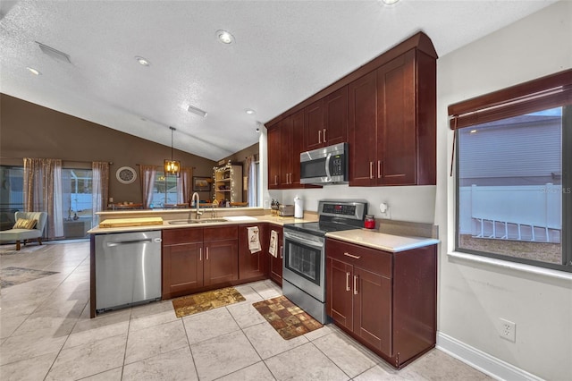 kitchen with a peninsula, a textured ceiling, a sink, vaulted ceiling, and stainless steel appliances