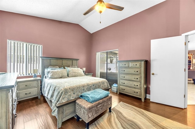bedroom featuring a ceiling fan, wood finished floors, and high vaulted ceiling