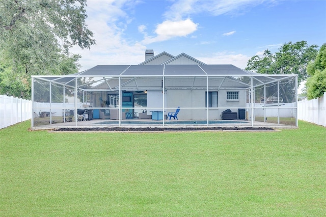 rear view of house featuring a fenced backyard, a swimming pool, a lanai, and a yard