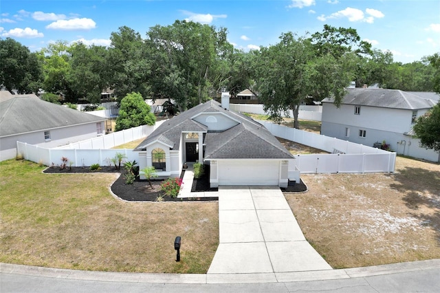 view of front of property with roof with shingles, a fenced backyard, a front lawn, concrete driveway, and an attached garage