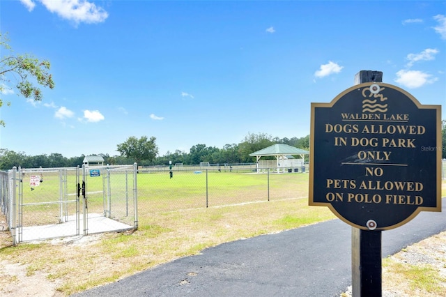 surrounding community featuring a yard, fence, and a gate