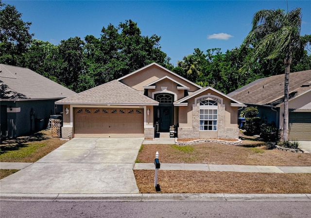 2604 Clareside Dr, Valrico, FL 33596 - ranch-style home with a garage, concrete driveway, stucco siding, and stone siding