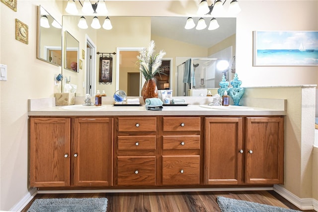 2604 Clareside Dr, Valrico, FL 33596 - bathroom featuring wood finished floors, double vanity, a shower stall, vaulted ceiling, and baseboards
