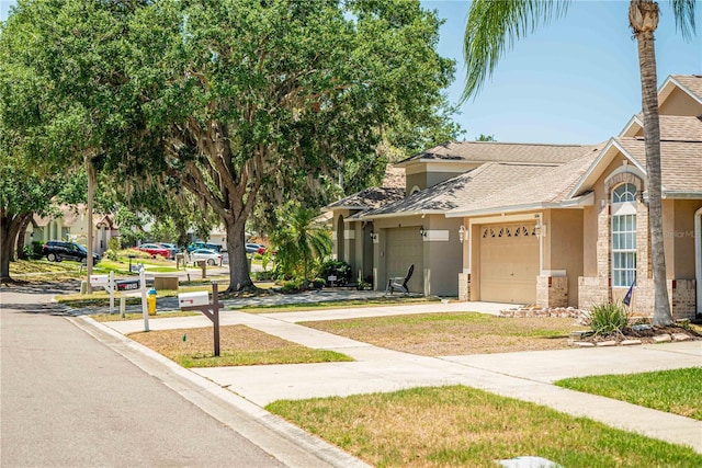2604 Clareside Dr, Valrico, FL 33596 - view of front of house featuring stucco siding, a garage, concrete driveway, stone siding, and roof with shingles