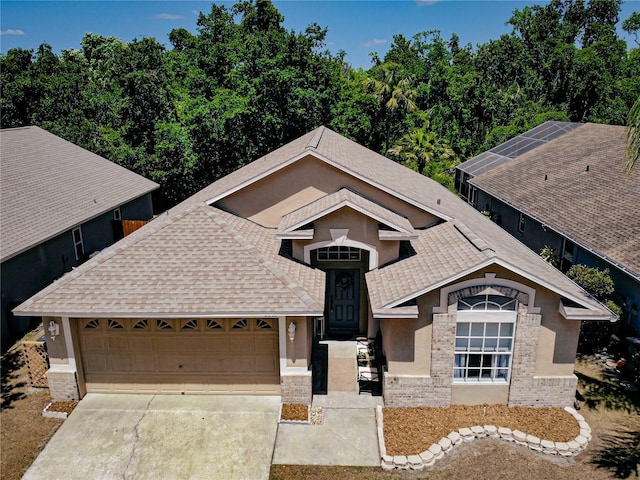 2604 Clareside Dr, Valrico, FL 33596 - view of front of home with concrete driveway, an attached garage, a shingled roof, stucco siding, and brick siding