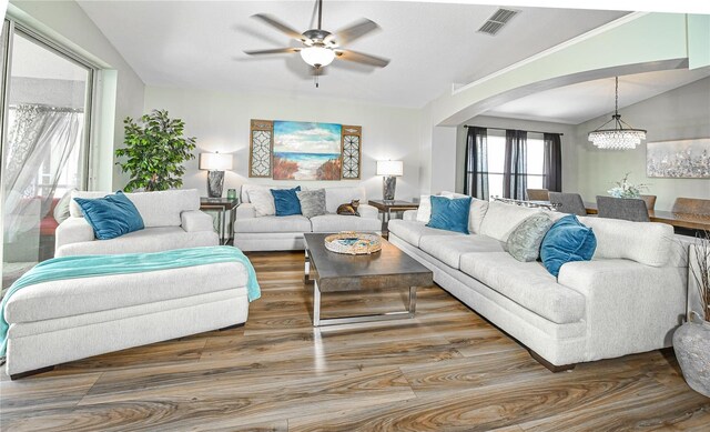 2604 Clareside Dr, Valrico, FL 33596 - living room featuring arched walkways, vaulted ceiling, ceiling fan, wood finished floors, and a chandelier