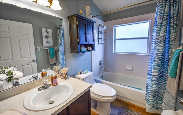 2604 Clareside Dr, Valrico, FL 33596 - full bath featuring wood finished floors, toilet, shower / bathtub combination with curtain, vanity, and vaulted ceiling