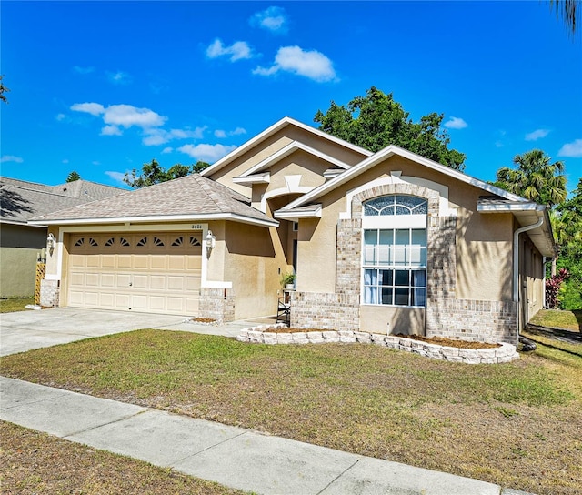 2604 Clareside Dr, Valrico, FL 33596 - view of front of home featuring stucco siding, a garage, driveway, a front lawn, and brick siding