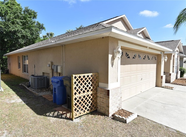 2604 Clareside Dr, Valrico, FL 33596 - view of side of home featuring stucco siding, a garage, roof with shingles, driveway, and central AC