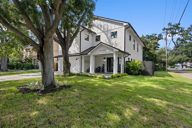 traditional-style home featuring board and batten siding, a porch, fence, and a front yard