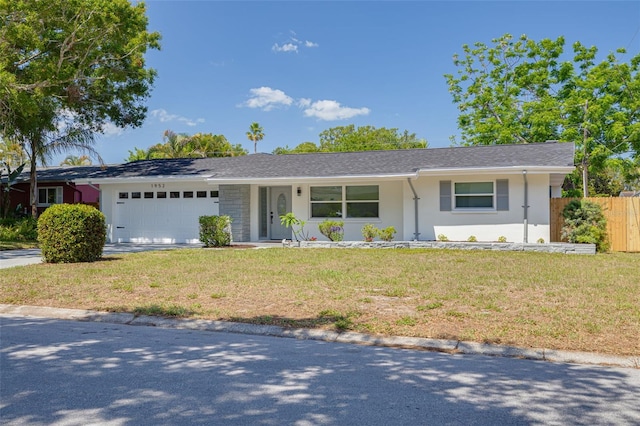single story home featuring a garage, fence, stucco siding, and a front lawn