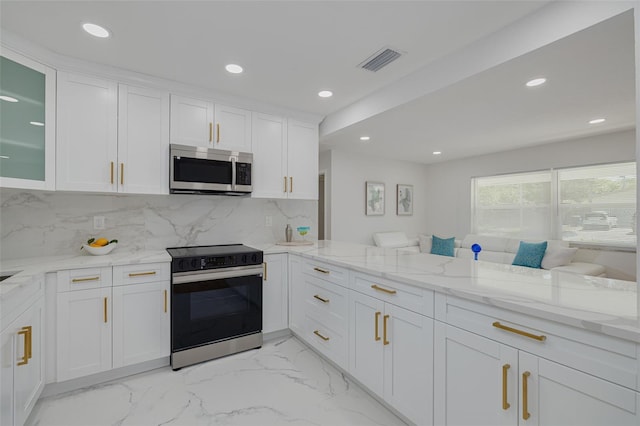 kitchen with white cabinets, electric range, light stone countertops, stainless steel microwave, and visible vents