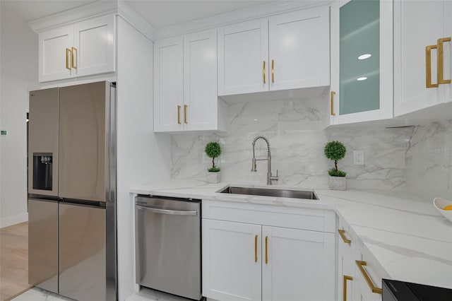 kitchen featuring a sink, white cabinetry, backsplash, and stainless steel appliances
