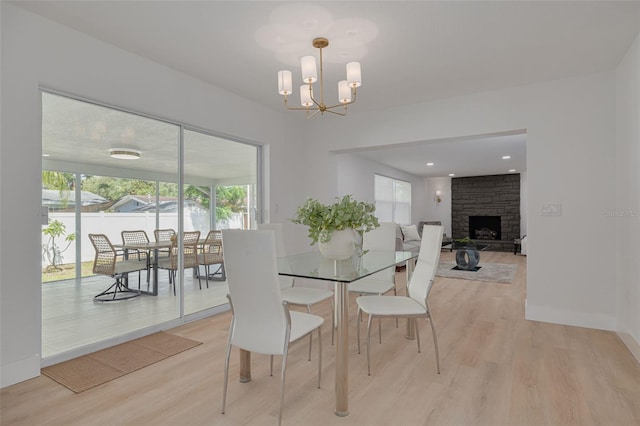 dining room featuring a fireplace, plenty of natural light, and light wood-type flooring
