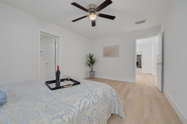 bedroom featuring a ceiling fan, baseboards, visible vents, and light wood-style flooring