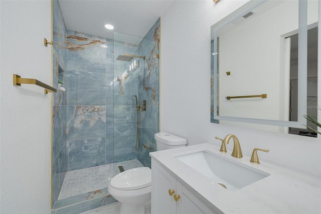 full bathroom featuring toilet, visible vents, a shower stall, and vanity