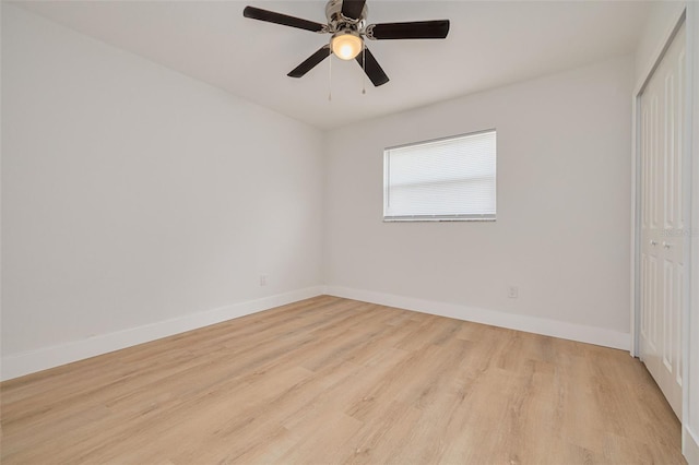 unfurnished bedroom with baseboards, light wood-style flooring, and a closet