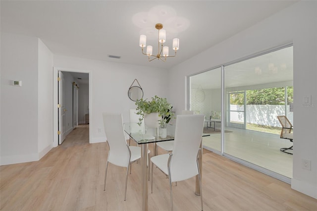 dining room featuring visible vents, light wood-style flooring, baseboards, and a chandelier