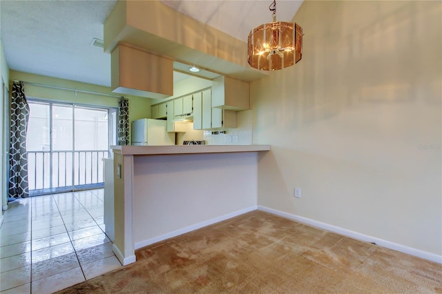 6428 Gloria Dr Unit 21, New Port Richey, FL 34653 - kitchen with light colored carpet, baseboards, freestanding refrigerator, a peninsula, and a notable chandelier