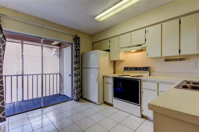 6428 Gloria Dr Unit 21, New Port Richey, FL 34653 - kitchen with backsplash, light countertops, under cabinet range hood, white appliances, and light tile patterned flooring