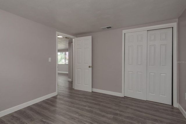 3601 Grayton Dr, New Port Richey, FL 34652 - unfurnished bedroom featuring baseboards, dark wood-style flooring, and a closet