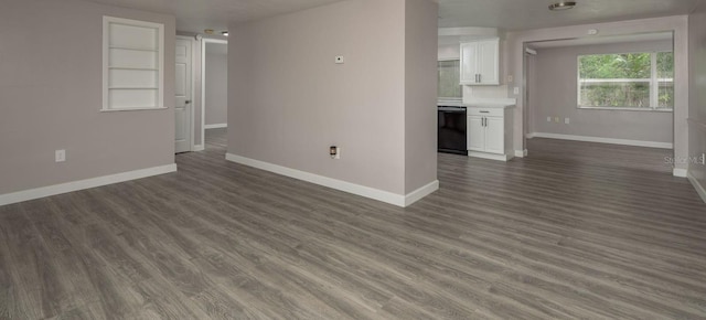 3601 Grayton Dr, New Port Richey, FL 34652 - unfurnished living room featuring baseboards and dark wood finished floors