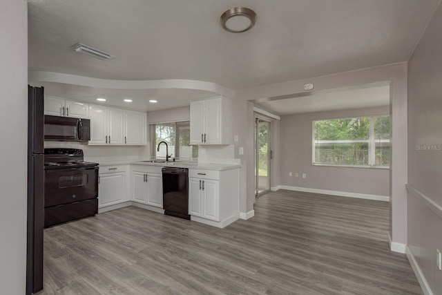 3601 Grayton Dr, New Port Richey, FL 34652 - kitchen with black appliances, a sink, light countertops, white cabinetry, and recessed lighting