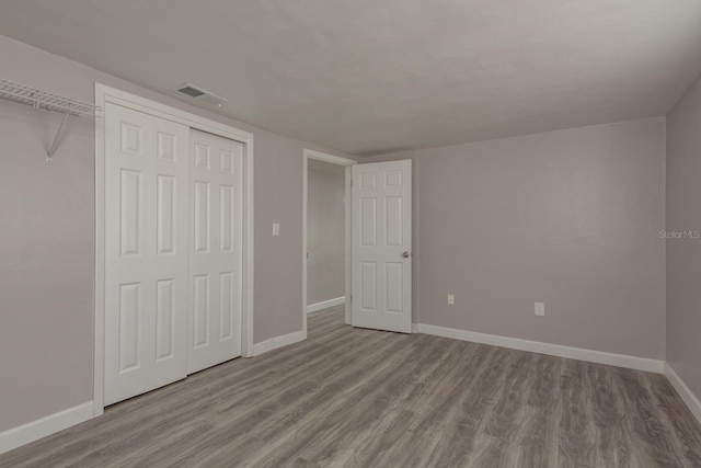 3601 Grayton Dr, New Port Richey, FL 34652 - unfurnished bedroom featuring wood finished floors, baseboards, and a closet