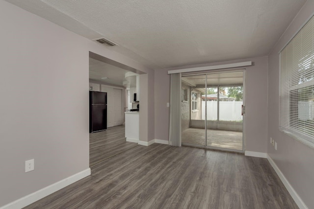 3601 Grayton Dr, New Port Richey, FL 34652 - spare room with dark wood-style flooring, baseboards, and a textured ceiling