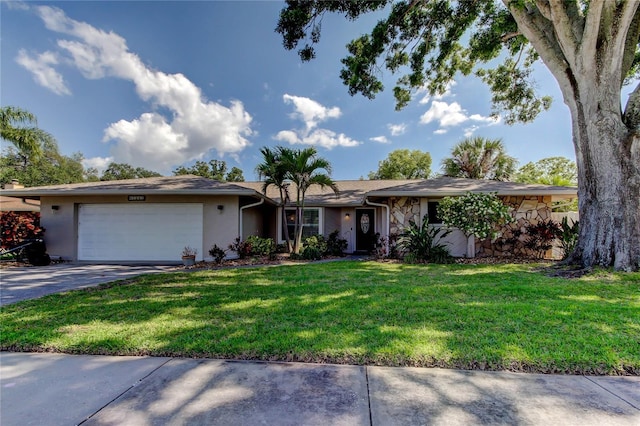 ranch-style house with stone siding, a garage, stucco siding, a front yard, and concrete driveway