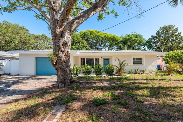 1152 Jackmar Rd, Dunedin, FL 34698 - view of front of house with an attached garage, stucco siding, and driveway