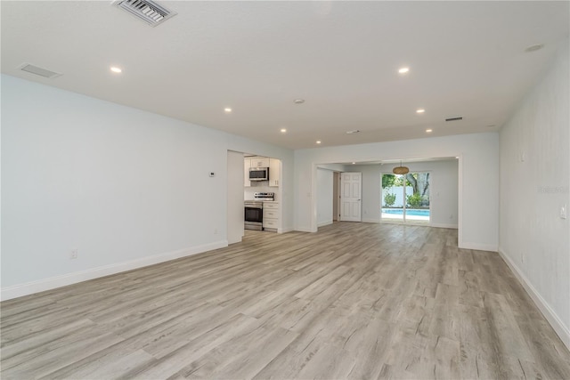 1152 Jackmar Rd, Dunedin, FL 34698 - unfurnished living room featuring light wood-style flooring, recessed lighting, and baseboards